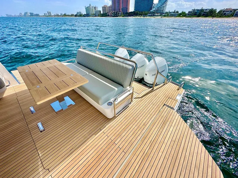 Slide: The Image of Luxury Schaefer 375 yacht deck with seating and table, overlooking ocean and city skyline, 2025 model. - 11