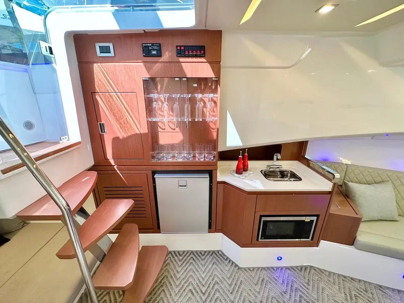 Slide: The Image of Interior of 2025 Schaefer 375 yacht with kitchenette, glass cabinet, and modern design. - 23