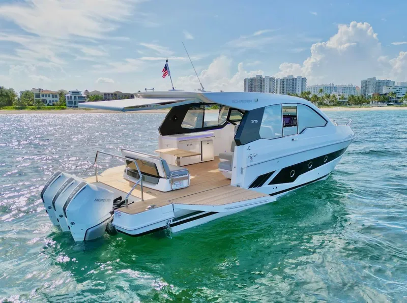 Slide: The Image of 2025 Schaefer 375 yacht cruising near a coastal city. - 8