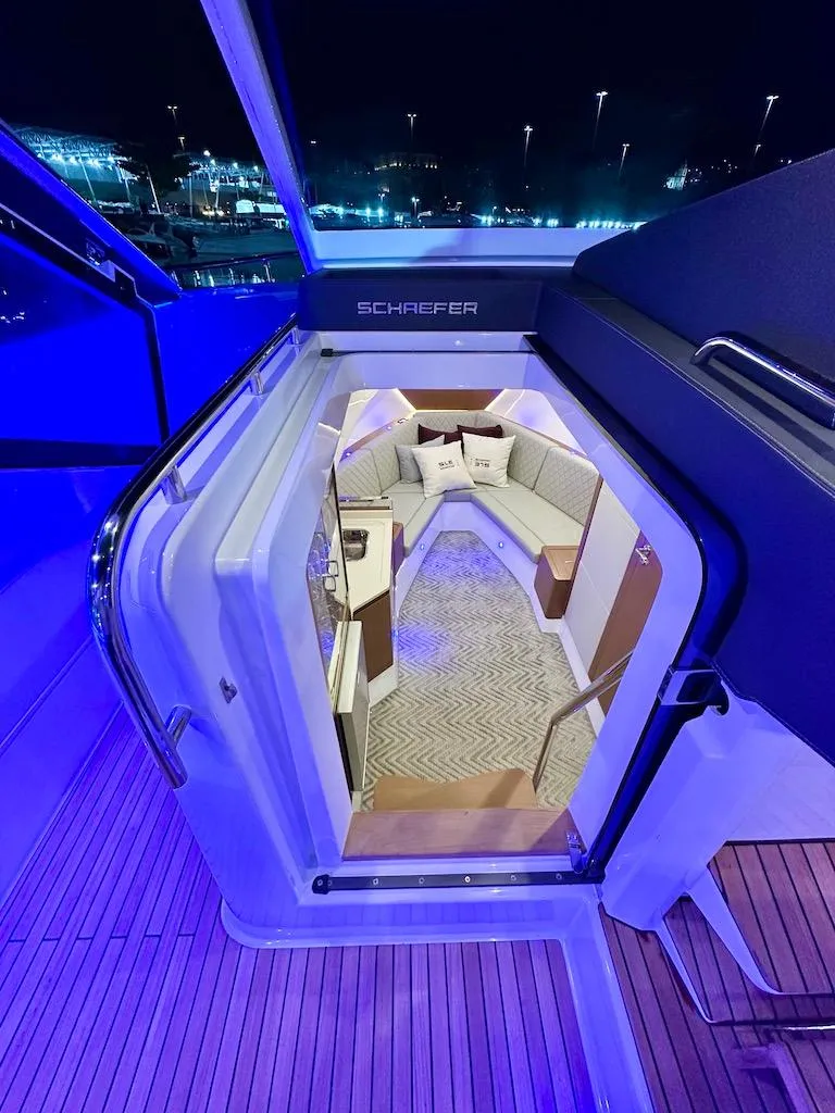 Slide: The Image of Schaefer 375 yacht interior at night, featuring cozy seating and modern design. - 21