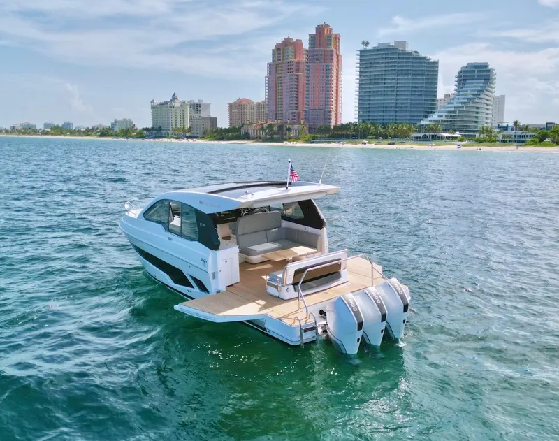 Slide: The Image of Schaefer 375 yacht cruising near a coastal city skyline, 2025 model. - 38