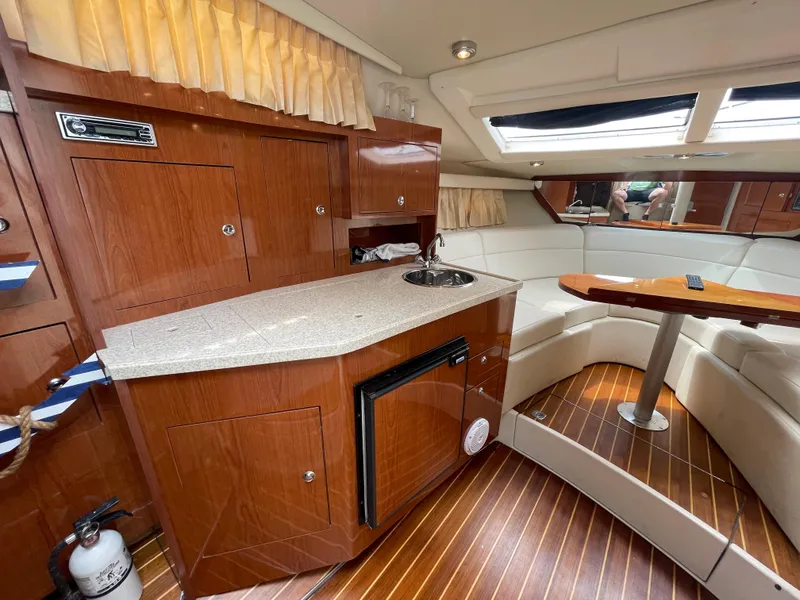 Slide: The Image of 2006 Regal 3060 Window Express yacht interior with kitchenette and seating area. - 16