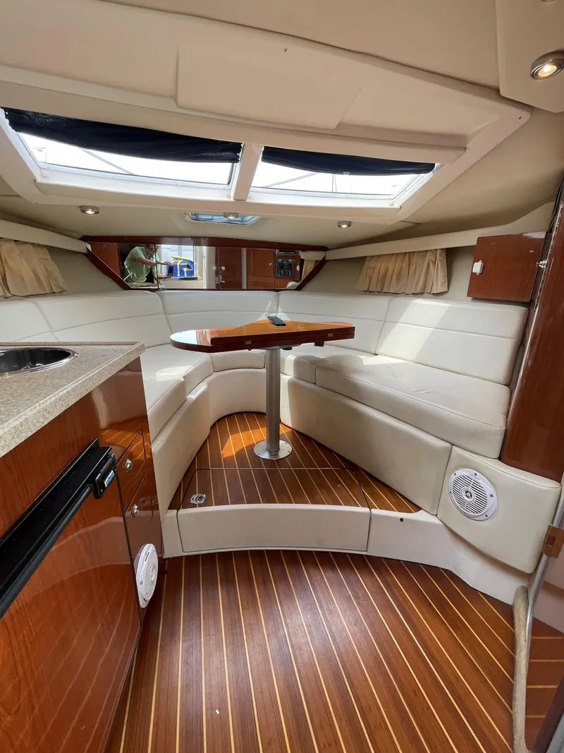 Slide: The Image of 2006 Regal 3060 Window Express interior with wood flooring and white seating. - 18
