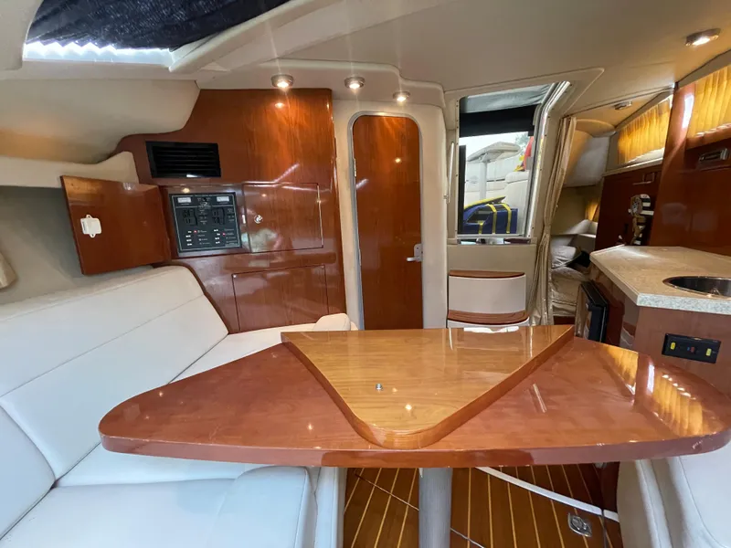 Slide: The Image of Interior of 2006 Regal 3060 Window Express yacht with wooden table and white seating. - 22