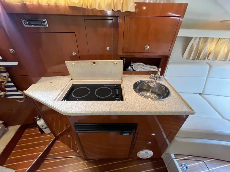 Slide: The Image of Compact kitchen area in a 2006 Regal 3060 Window Express boat with stove and sink. - 27