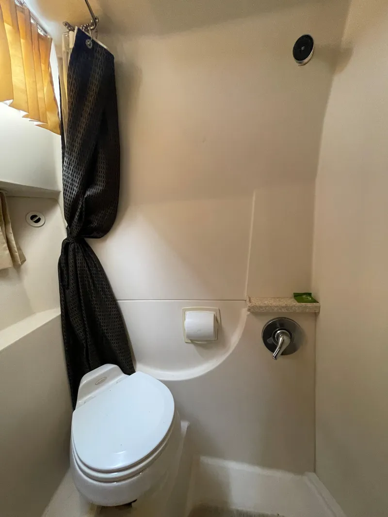 Slide: The Image of 2006 Regal 3060 Window Express boat bathroom with toilet, curtain, and toilet paper holder. - 34