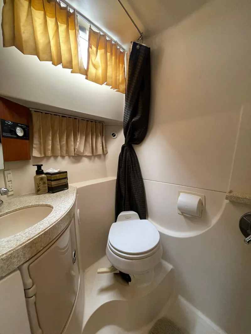 Slide: The Image of 2006 Regal 3060 Window Express boat bathroom with sink, toilet, and curtains. - 35