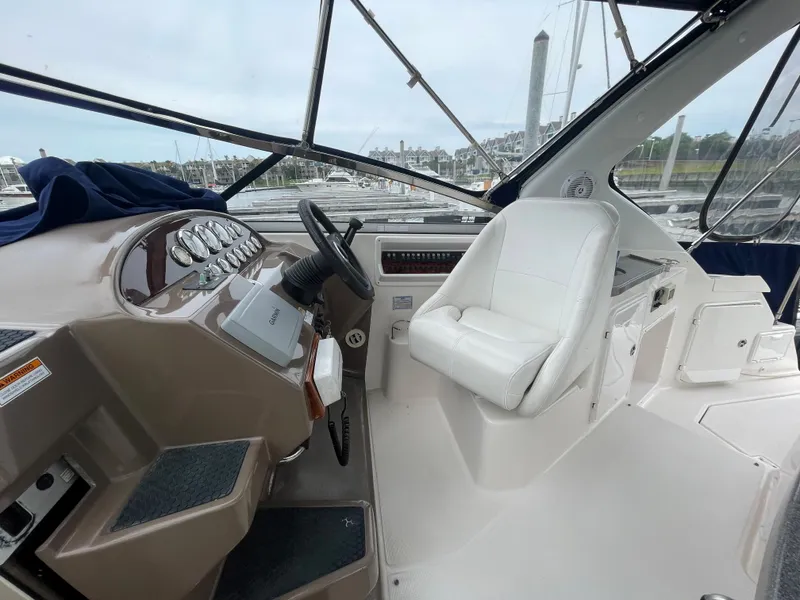 Slide: The Image of 2006 Regal 3060 Window Express boat cockpit with steering wheel and captain's chair. - 8