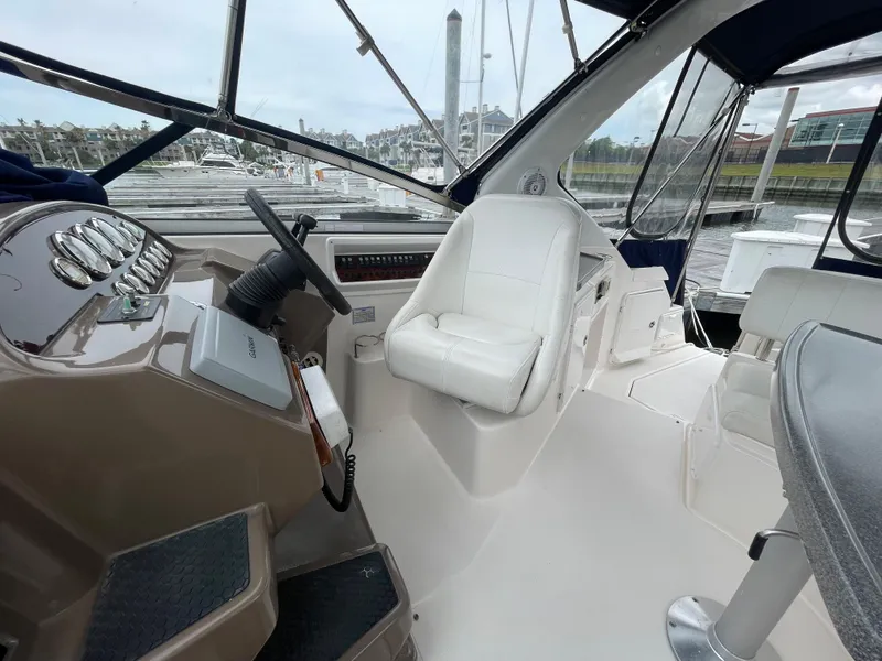 Slide: The Image of Interior of 2006 Regal 3060 Window Express boat with white captain's chair and steering console. - 9