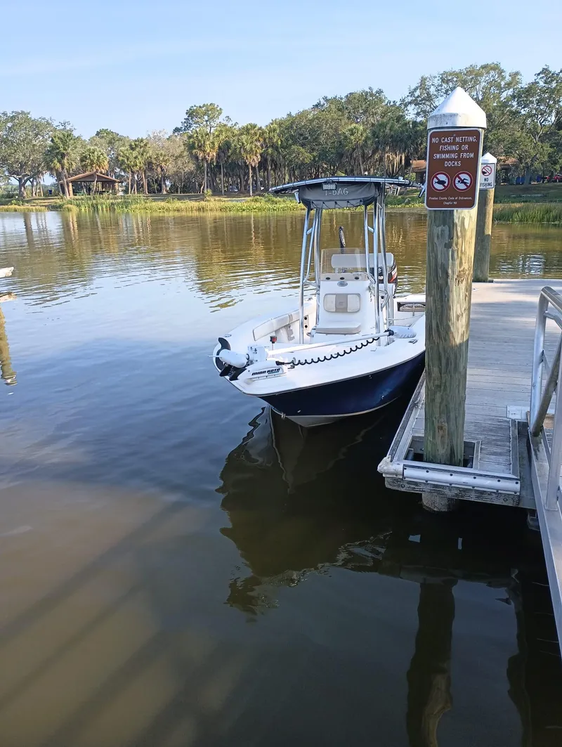 Slide: The Image of 2014 Carolina Skiff Sea Skiff 21 docked by a serene lake. - 20