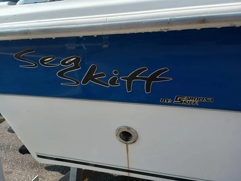 Slide: The Image of 2014 Carolina Skiff Sea Skiff 21 boat side view with logo. - 23