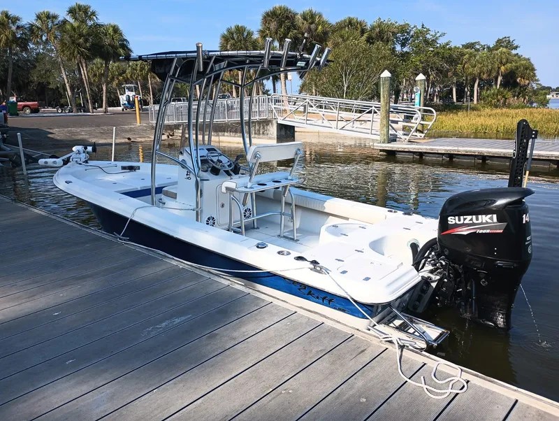 Slide: The Image of 2014 Carolina Skiff Sea Skiff 21 boat docked, featuring a Suzuki outboard motor. - 8
