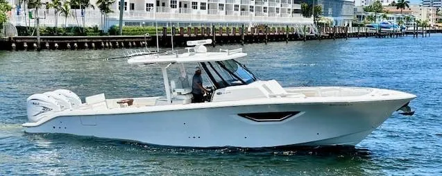 Slide: The Image of 2022 Pursuit S-378 Sport boat cruising on water near a dock. - 1