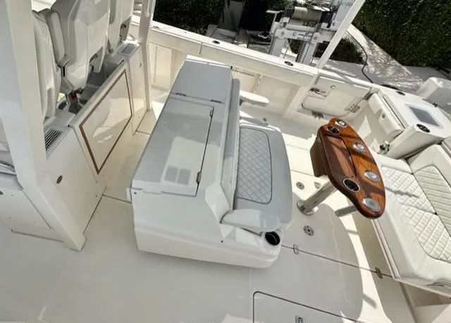 Slide: The Image of 2022 Pursuit S-378 Sport boat interior with seating and wooden table. - 11