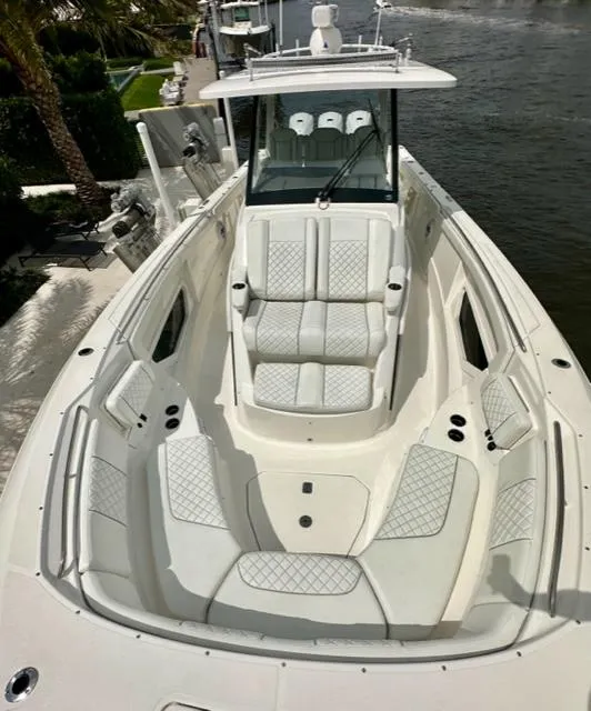 Slide: The Image of 2022 Pursuit S-378 Sport boat with luxurious seating and sleek design docked by the water. - 12