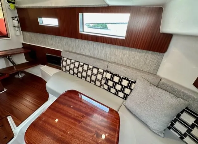 Slide: The Image of Interior of 2022 Pursuit S-378 Sport boat with modern seating and wooden table. - 15