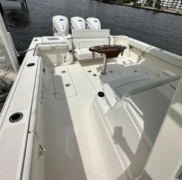 Slide: The Image of 2022 Pursuit S-378 Sport boat deck with seating and triple outboard engines. - 9