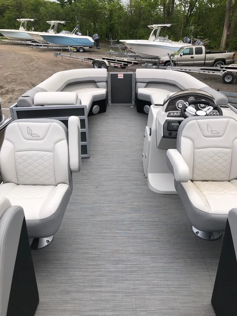 Slide: The Image of 2023 Lowe 250 pontoon boat interior with plush seating and modern dashboard. - 6