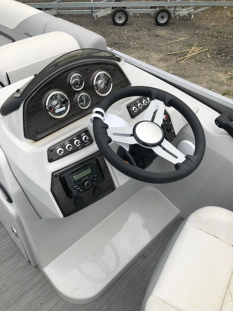 Slide: The Image of 2023 Lowe 250 boat dashboard with steering wheel and control panel. - 7