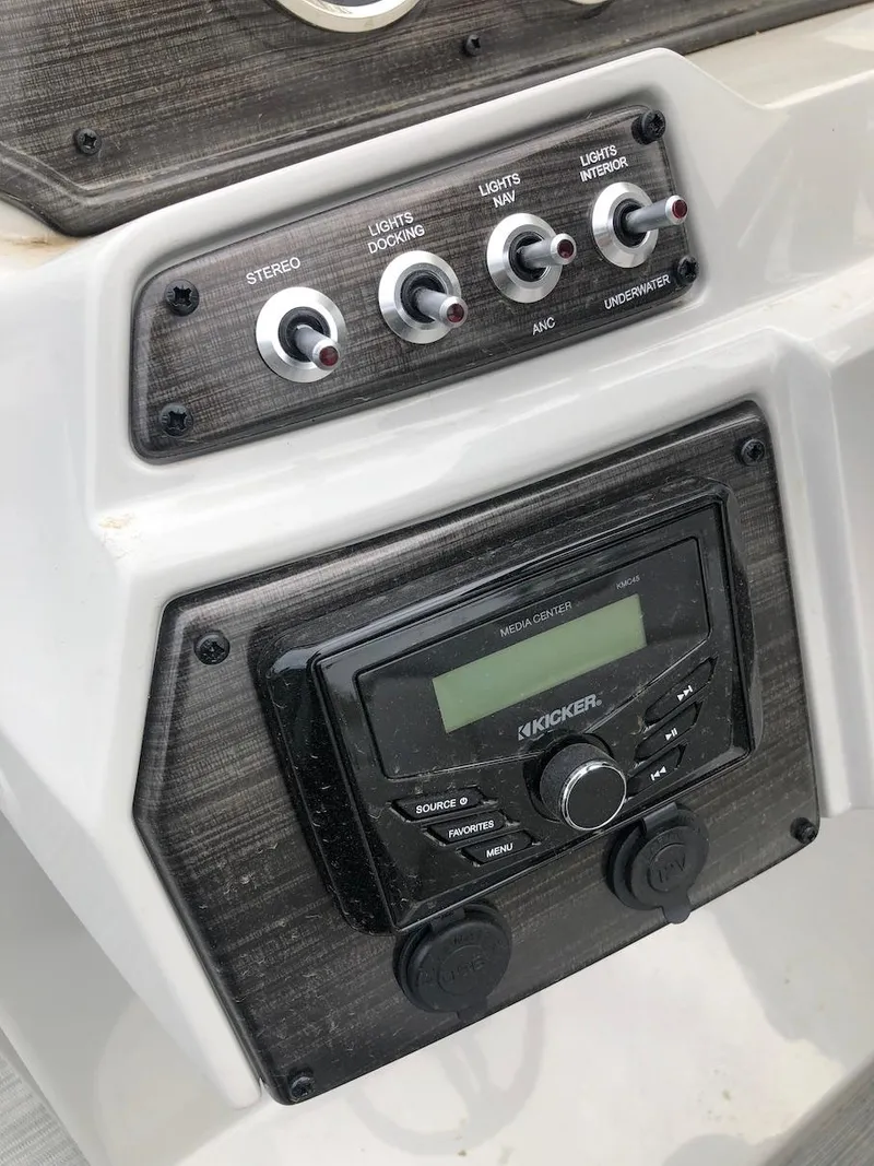 Slide: The Image of Control panel of a 2023 Lowe 250 boat with stereo and light switches. - 8