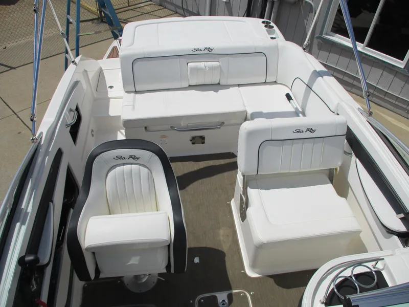 Slide: The Image of 2015 Sea Ray 240 Sundeck interior with white seating and helm chair. - 11