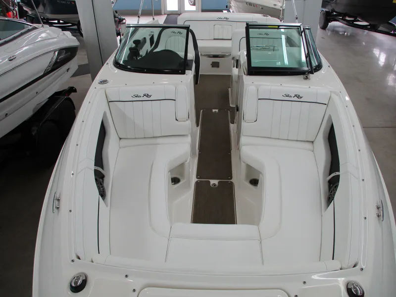 Slide: The Image of 2015 Sea Ray 240 Sundeck boat with spacious seating and sleek design in a showroom. - 13