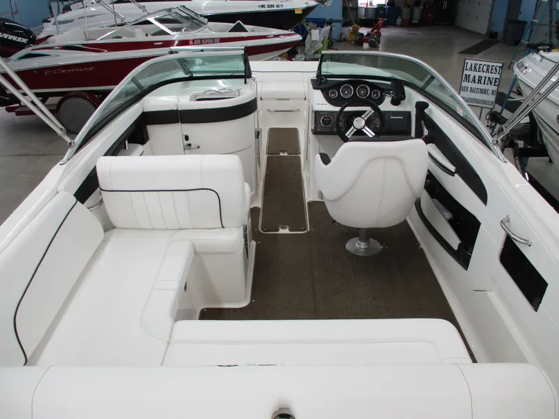 Slide: The Image of 2015 Sea Ray 240 Sundeck interior with white seating and steering console. - 15