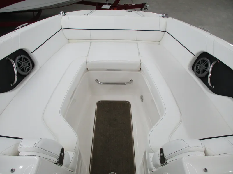 Slide: The Image of 2015 Sea Ray 240 Sundeck interior with white seating and built-in speakers. - 17