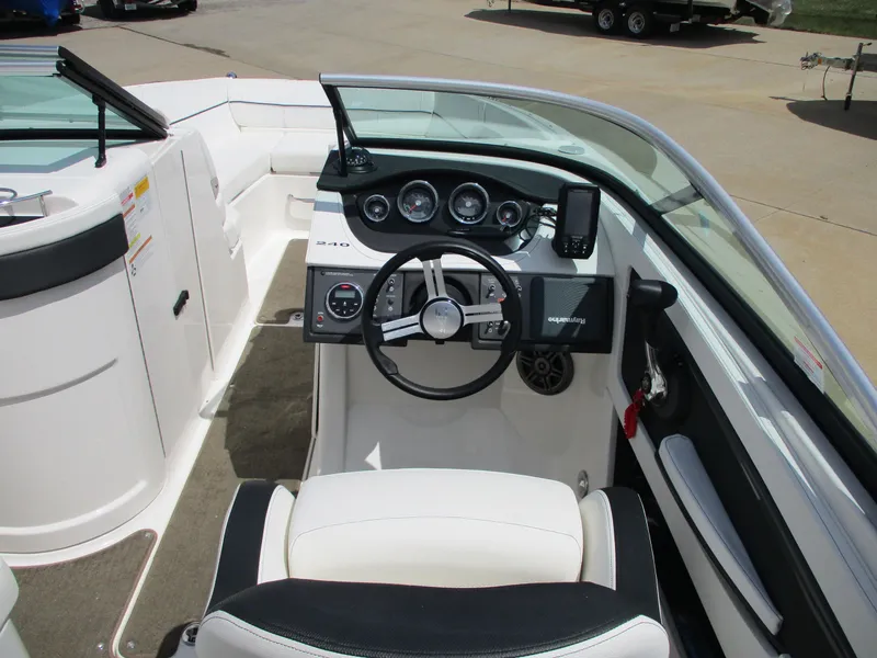 Slide: The Image of 2015 Sea Ray 240 Sundeck boat interior with steering wheel and dashboard controls. - 8