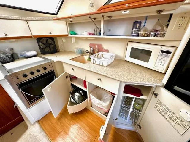 Slide: The Image of 2000 Silverton 392 Motor Yacht kitchen with stove, microwave, and ample storage. - 11