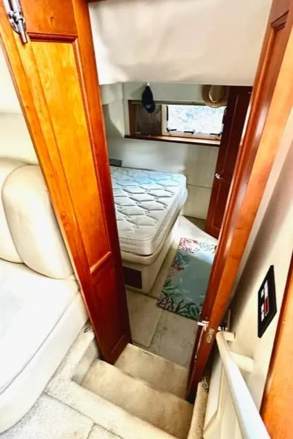 Slide: The Image of Interior cabin of 2000 Silverton 392 Motor Yacht with bed and wooden doors. - 12