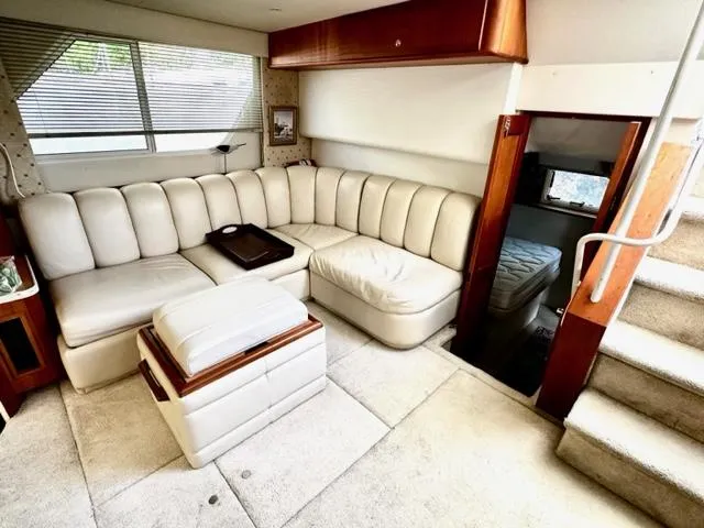 Slide: The Image of Interior of 2000 Silverton 392 Motor Yacht with white leather seating and wooden accents. - 16