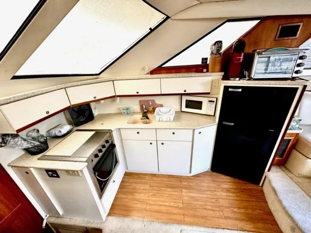 Slide: The Image of Interior kitchen of a 2000 Silverton 392 Motor Yacht with appliances and wooden flooring. - 17