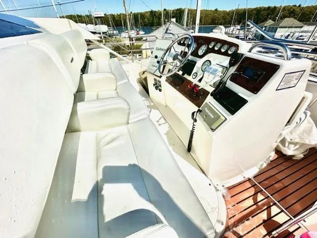 Slide: The Image of 2000 Silverton 392 Motor Yacht helm with white seating and control panel. - 25