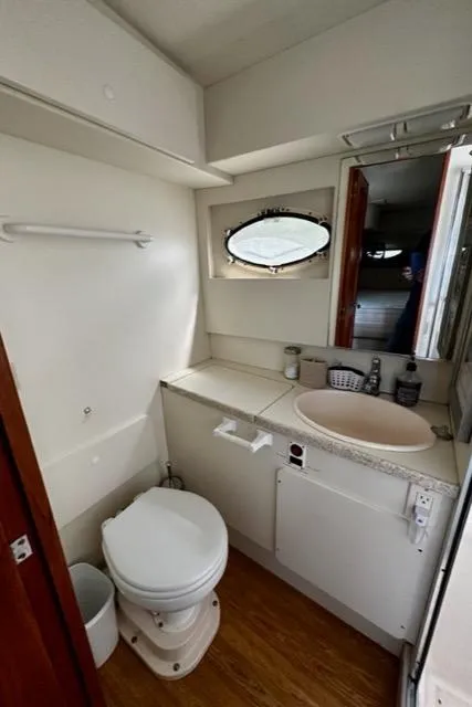 Slide: The Image of 2000 Silverton 392 Motor Yacht bathroom with toilet, sink, and mirror. - 27