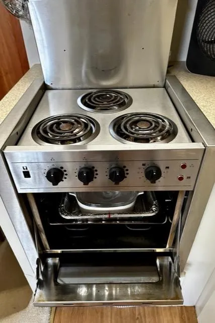 Slide: The Image of 2000 Silverton 392 Motor Yacht kitchen stove with oven and four burners. - 31