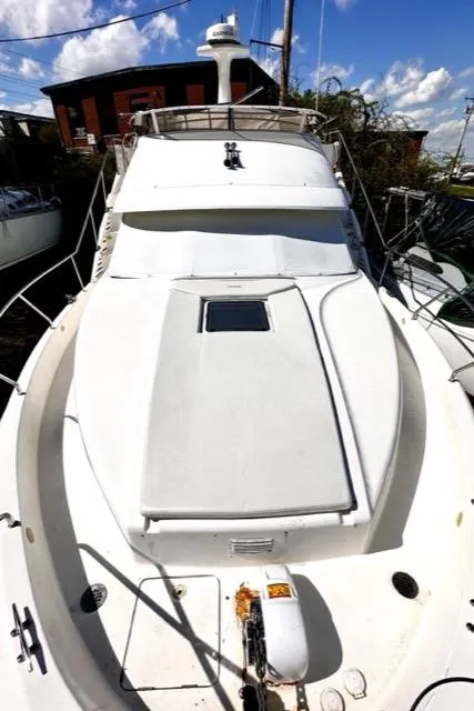 Slide: The Image of 2000 Silverton 392 Motor Yacht with white exterior docked at marina. - 44