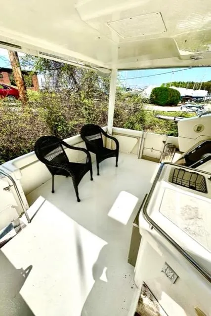 Slide: The Image of Spacious deck of a 2000 Silverton 392 Motor Yacht with two black chairs. - 6