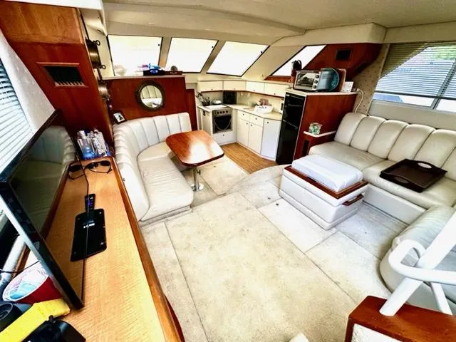 Slide: The Image of Interior of a 2000 Silverton 392 Motor Yacht with seating, table, and kitchen area. - 8