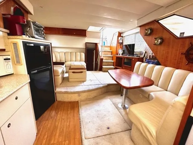 Slide: The Image of Interior of a 2000 Silverton 392 Motor Yacht with seating, table, and kitchen area. - 9
