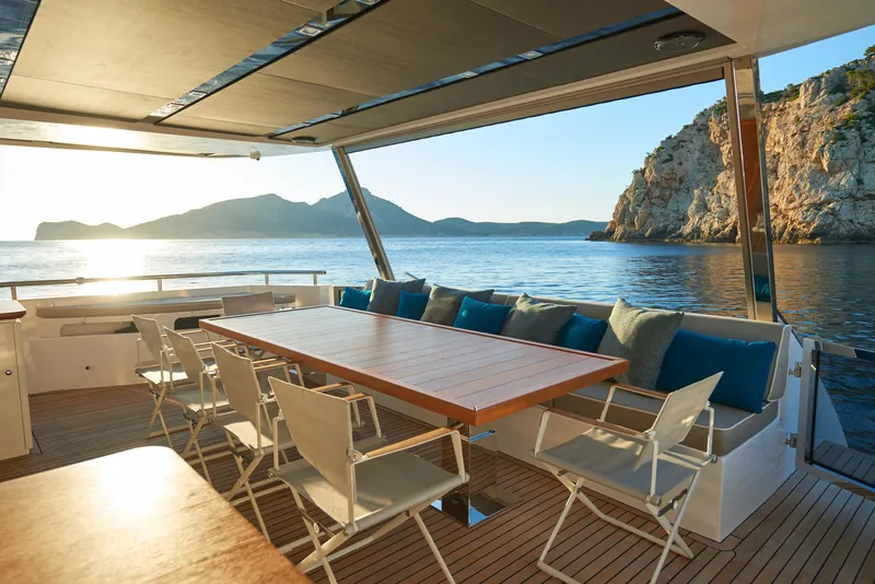 Slide: The Image of Luxury outdoor dining area on the 2023 Astondoa 110 Century yacht, with ocean and mountain views. - 23