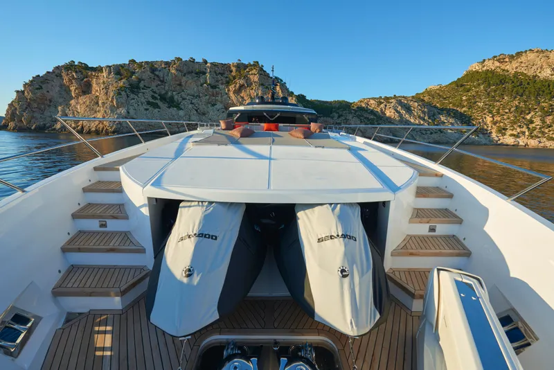 Slide: The Image of Astondoa 110 Century 2023 yacht with Sea-Doo jet skis, docked in a scenic coastal area. - 9