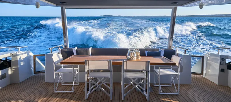 Slide: The Image of Astondoa 100 Century 2023 yacht's rear deck with ocean view and dining area. - 23