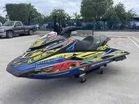 Slide: The Image of 2017 Yamaha Boats GP1800 jet ski with vibrant graphics in a parking lot. - 5