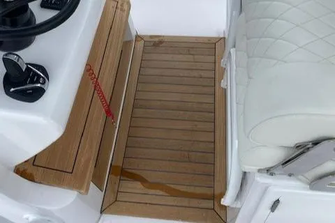 Slide: The Image of Cockpit of 2023 Jupiter 32 boat with teak flooring and white leather seating. - 11