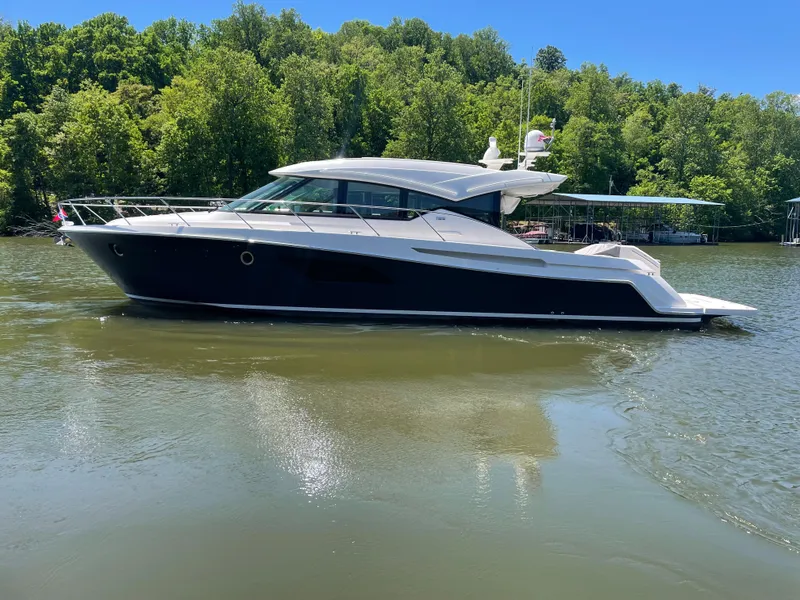 The Image of 2019 Tiara Yachts C53 cruising on a lake with lush green trees in the background. - 0