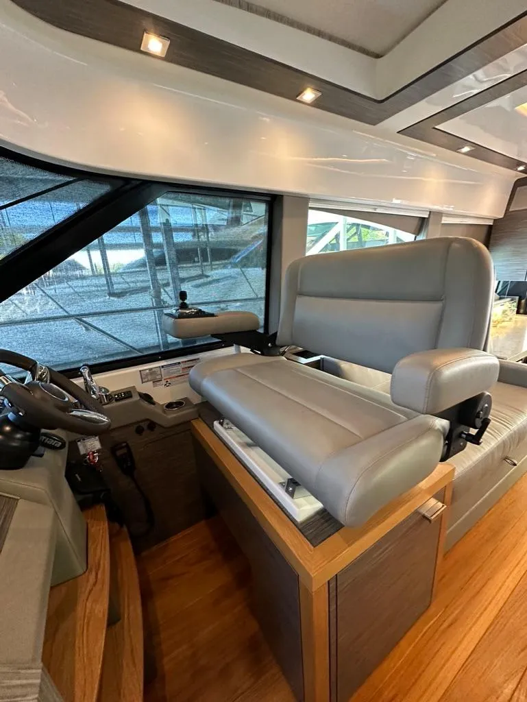 Slide: The Image of 2019 Tiara Yachts C53 helm station with luxurious leather seating and modern controls. - 18