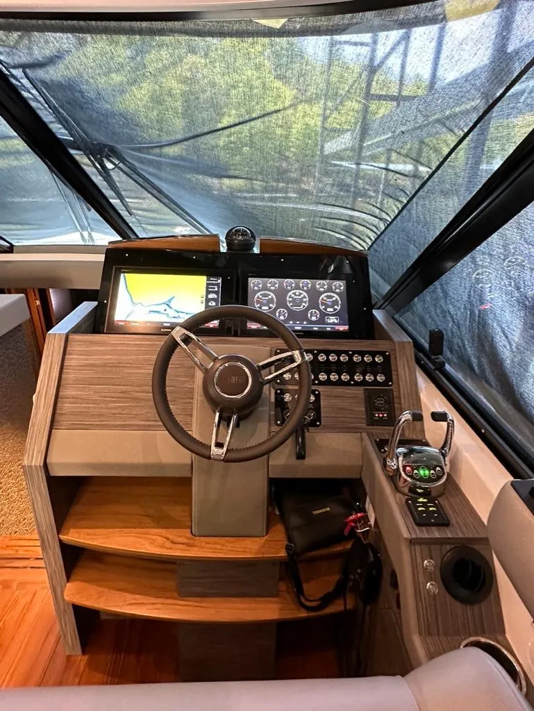 Slide: The Image of 2019 Tiara Yachts C53 helm station with advanced navigation controls. - 19