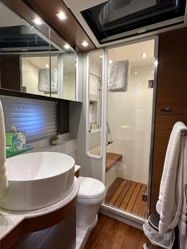 Slide: The Image of Luxurious bathroom in a 2019 Tiara Yachts C53 with modern fixtures and wooden accents. - 23