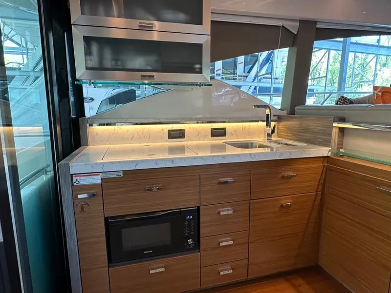 Slide: The Image of Modern kitchen area in a 2019 Tiara Yachts C53, featuring sleek cabinetry and built-in appliances. - 14